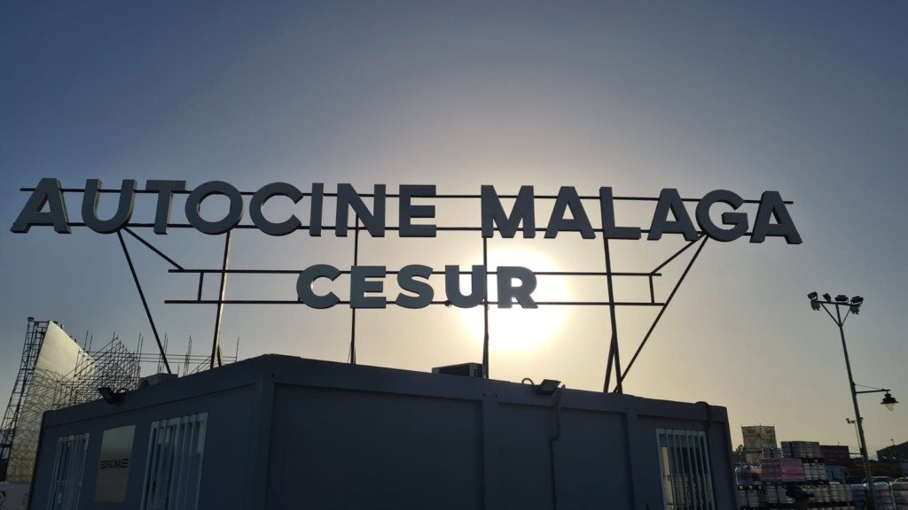 Letras metálicas del Autocine Málaga Cesur montadas sobre estructura en la cubierta de un edificio