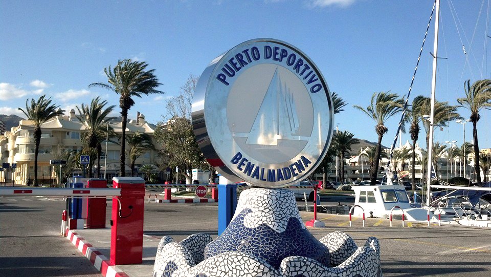 Acceso al Puerto Deportivo de Benalmádena con el emblema del puerto y barreras de entrada