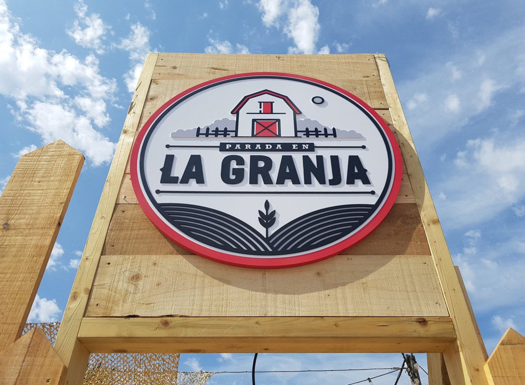 Rótulo circular del restaurante La Granja sobre estructura de madera