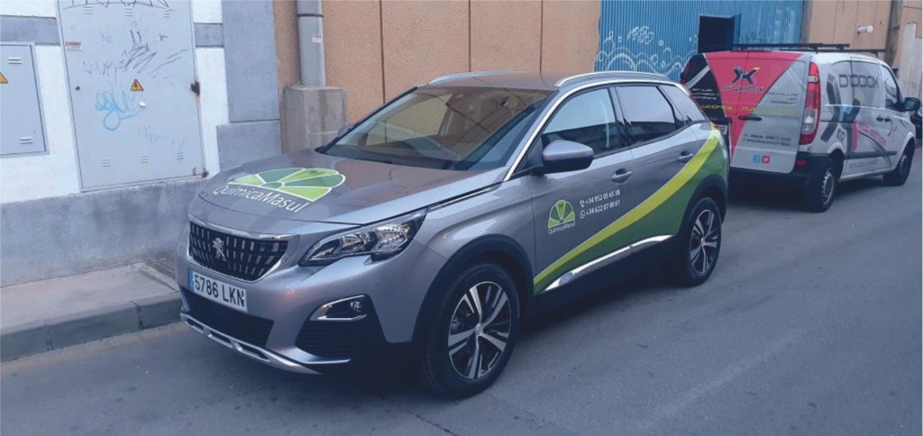 Coche comercial de Química Masul con rotulación parcial junto a una furgoneta rotulada de Dodox