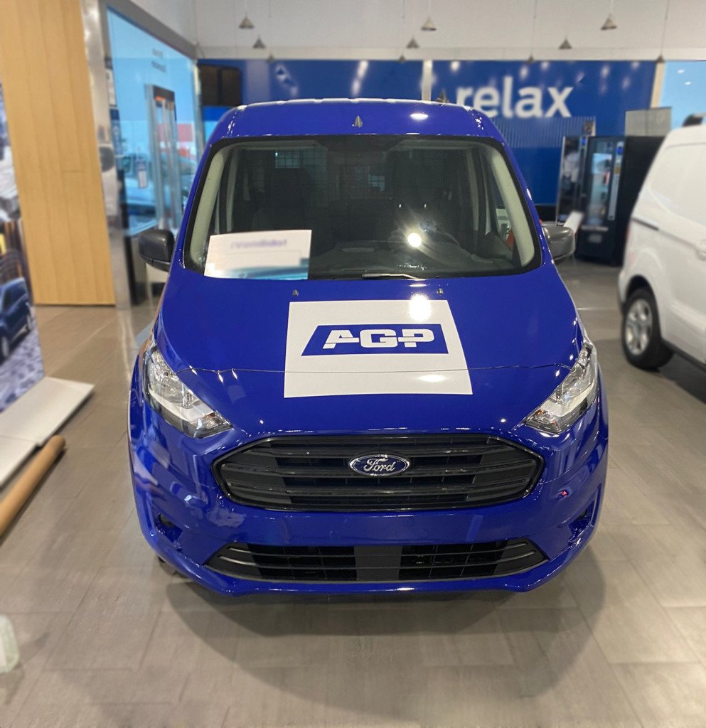 Instalador de Dodox colocando vinilo verde y amarillo en el lateral de un coche de empresa