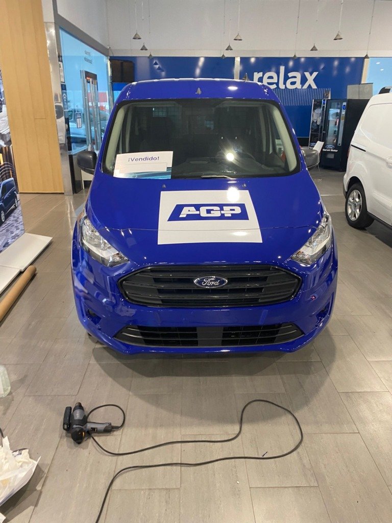 Furgoneta Ford rotulada en un showroom con pared vinilada