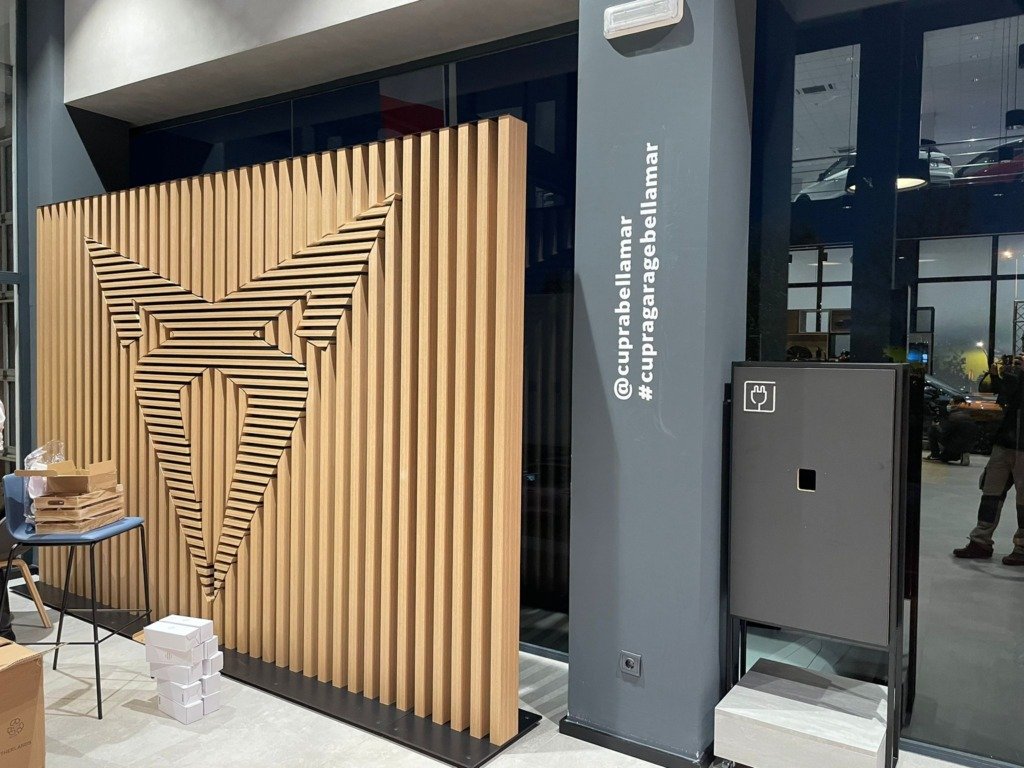 Panel de lamas de madera con el logotipo de Cupra en la entrada de un concesionario
