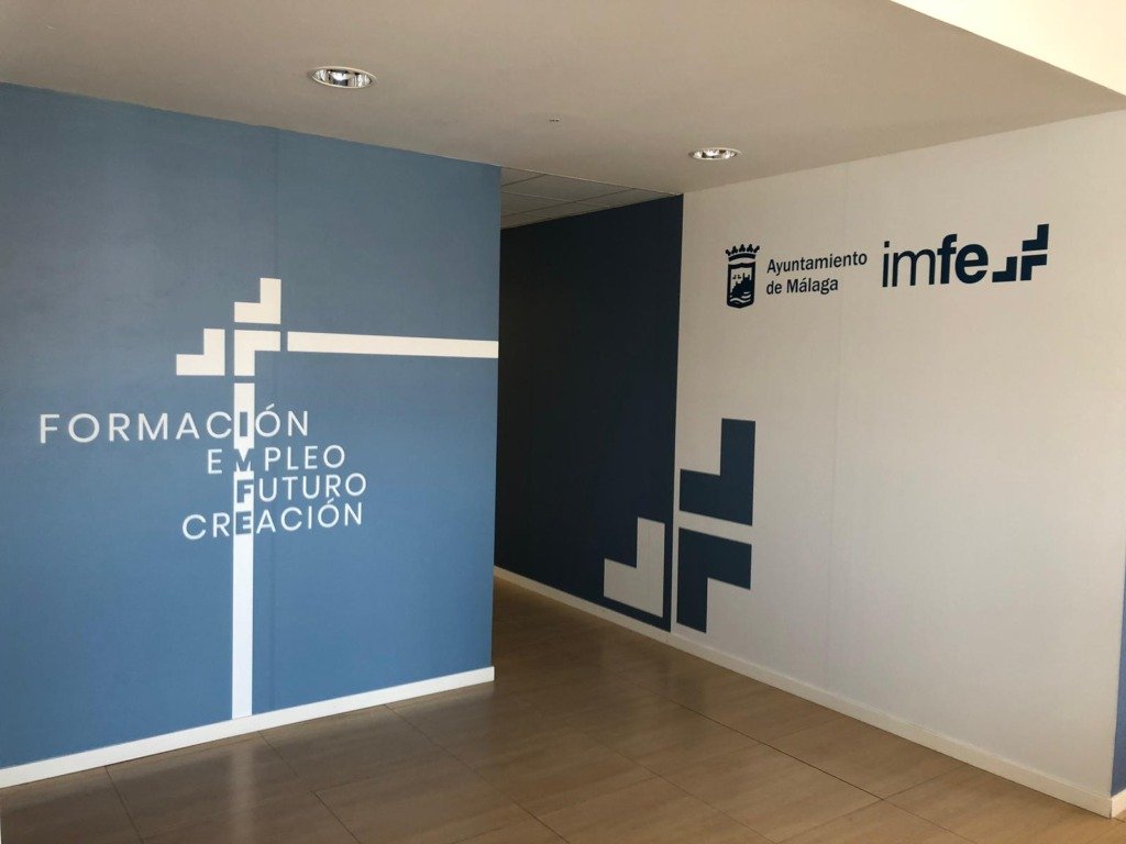 Pared de un centro de formación y empleo con vinilo de gran formato y logotipo institucional