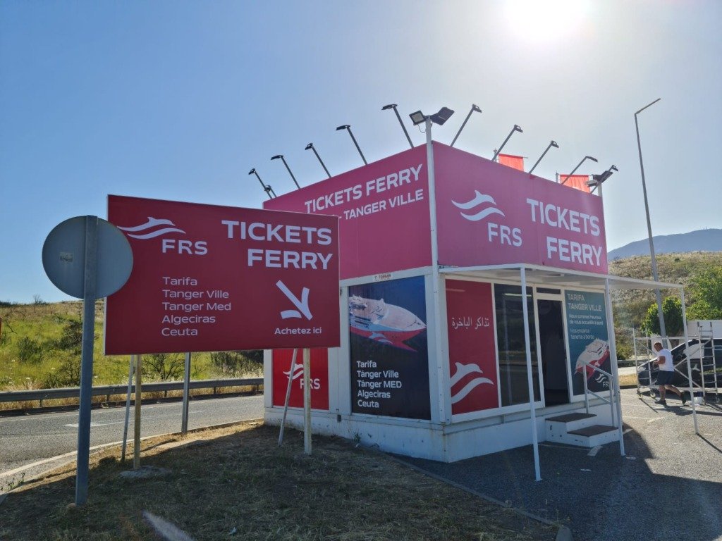 Taquilla de una naviera rotulada con vinilos exteriores y la imagen de un ferry