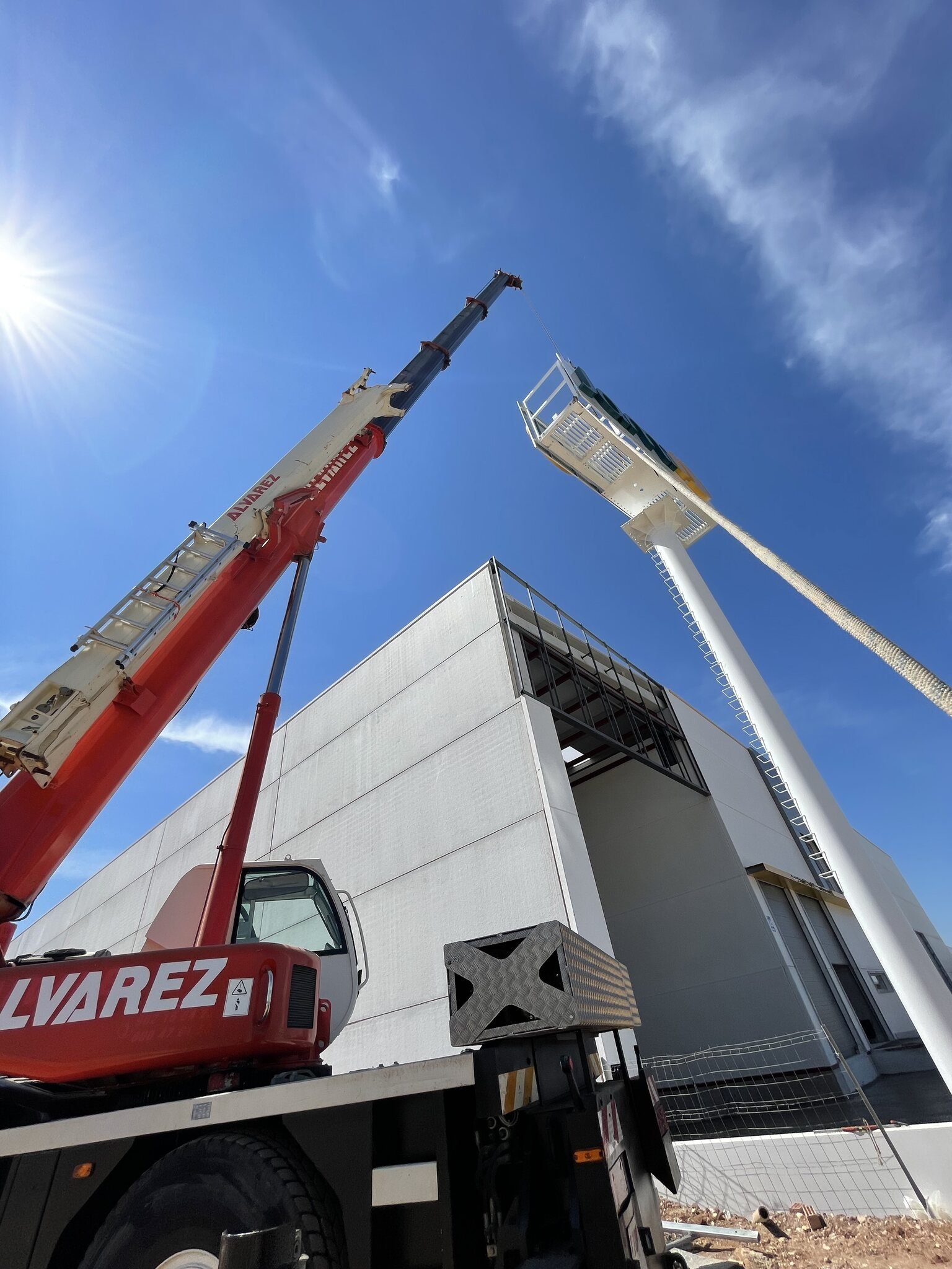 Grúa montando el monoposte publicitario de Jami junto a su nave